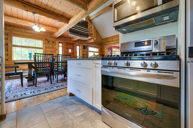 kitchen featuring pendant lighting, light hardwood / wood-style flooring, white cabinetry, appliances with stainless steel finishes, and an inviting chandelier