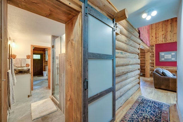 interior space featuring lofted ceiling, hardwood / wood-style floors, an enclosed shower, log walls, and toilet