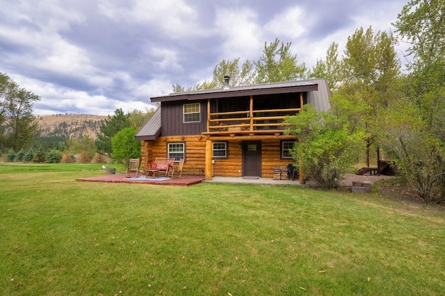 rear view of house with a yard, a mountain view, and a patio area