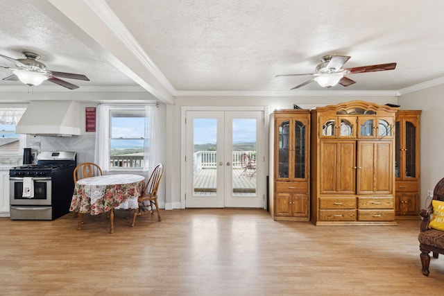 interior space featuring light wood-type flooring, a textured ceiling, crown molding, ceiling fan, and french doors