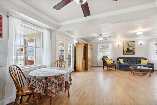 dining area featuring a textured ceiling, light hardwood / wood-style floors, crown molding, ceiling fan, and french doors