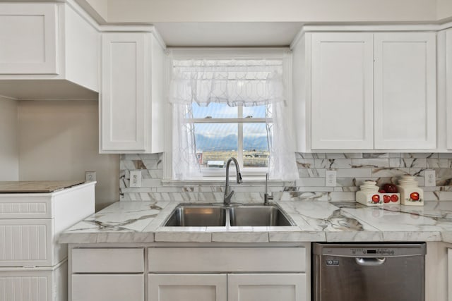 kitchen with dishwasher, light stone counters, sink, white cabinetry, and decorative backsplash