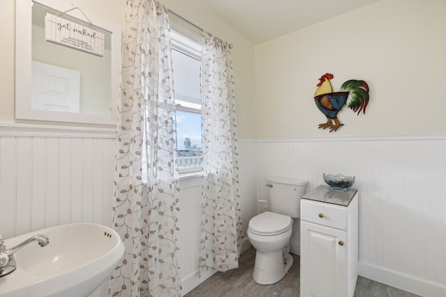 bathroom with toilet, sink, and hardwood / wood-style flooring