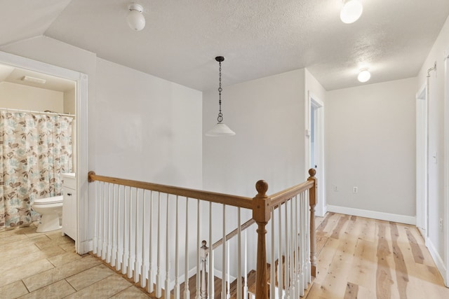 corridor featuring light hardwood / wood-style floors and a textured ceiling