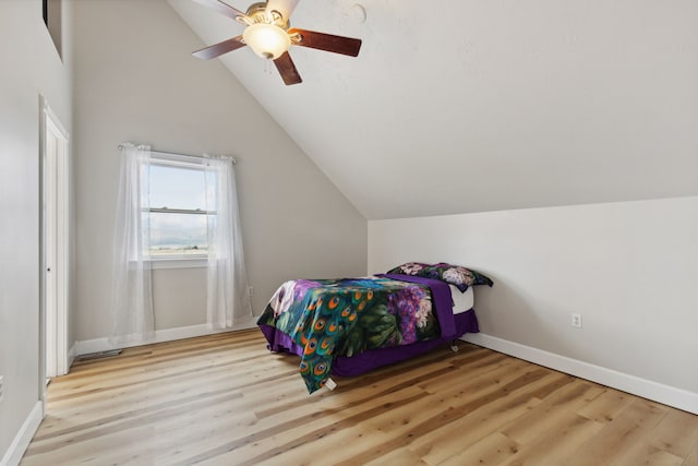 bedroom featuring light wood-type flooring, vaulted ceiling, and ceiling fan