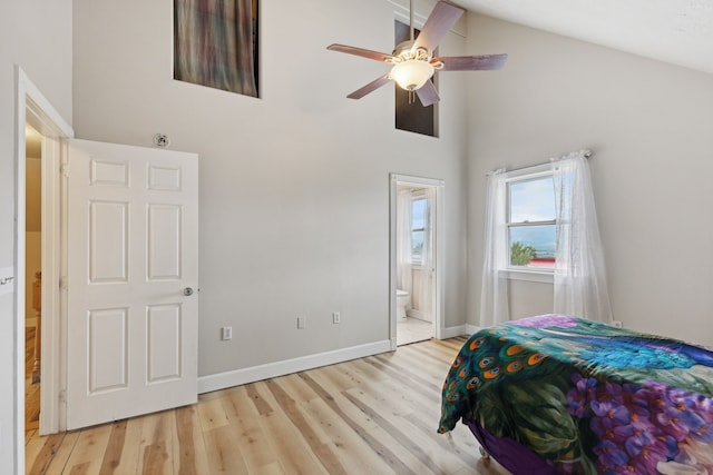 bedroom with high vaulted ceiling, light hardwood / wood-style floors, ensuite bathroom, and ceiling fan