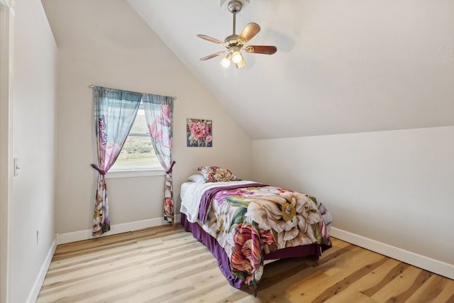 bedroom featuring ceiling fan, light wood-type flooring, and vaulted ceiling