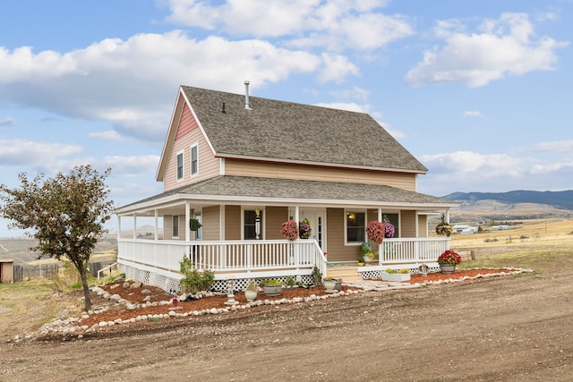 farmhouse-style home with a mountain view and covered porch