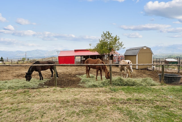 view of yard featuring a storage shed, a mountain view, and a rural view