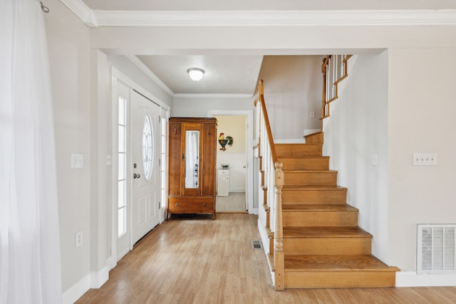 foyer with light hardwood / wood-style flooring and crown molding