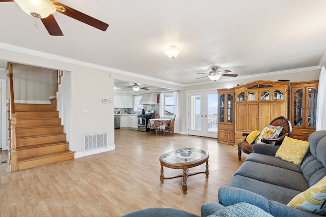 living room with ornamental molding, light hardwood / wood-style floors, and ceiling fan