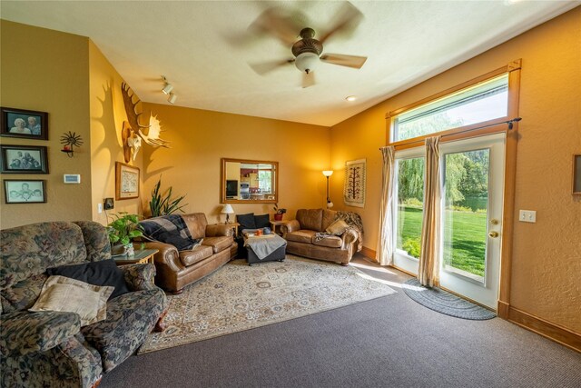 living room with dark colored carpet, ceiling fan, a tile fireplace, and a textured ceiling