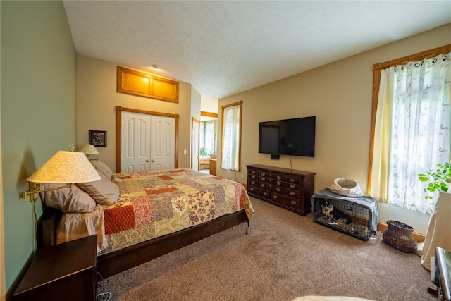 carpeted bedroom featuring a textured ceiling and a closet