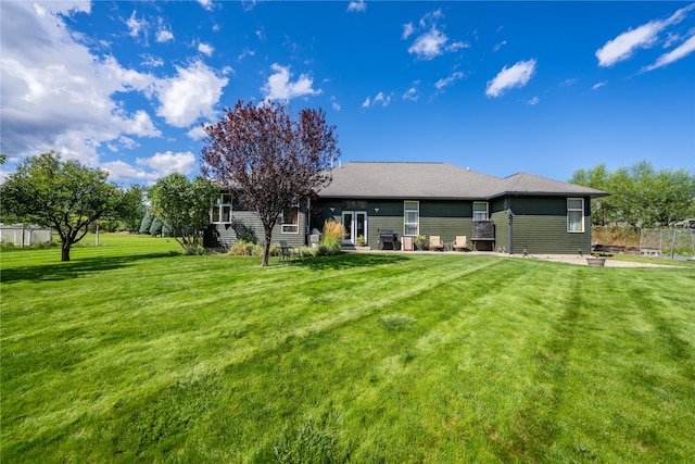 back of house featuring a lawn and a patio area