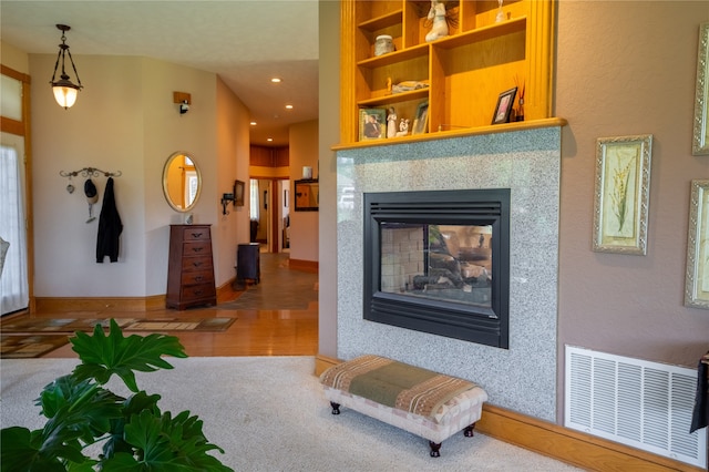 living room featuring a multi sided fireplace and hardwood / wood-style flooring