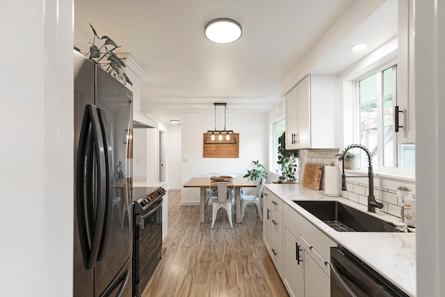 kitchen with stainless steel refrigerator, black range with electric stovetop, decorative light fixtures, dishwashing machine, and white cabinets