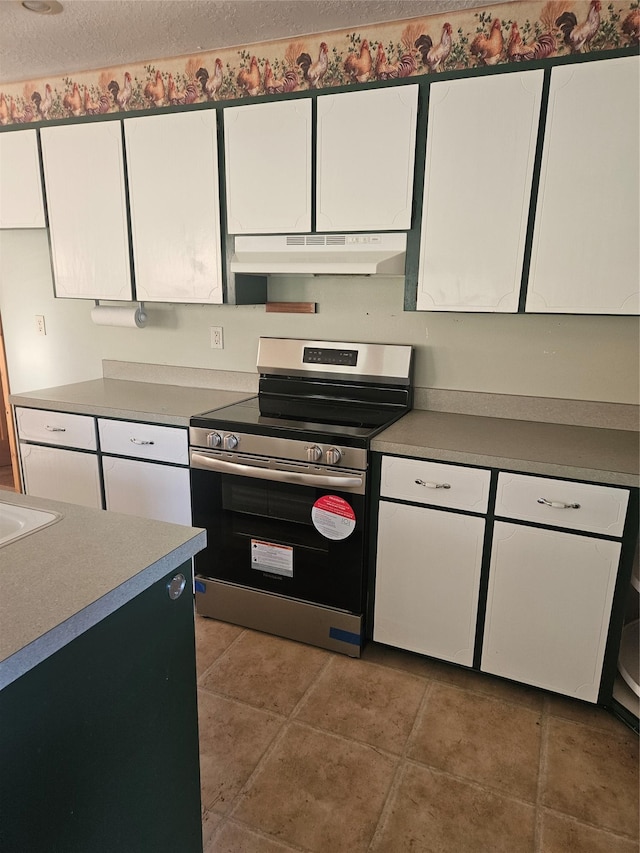 72878 Lemlama Trl, Arlee, MT 59821 - kitchen featuring light tile patterned floors, a textured ceiling, under cabinet range hood, white cabinetry, and stainless steel electric stove