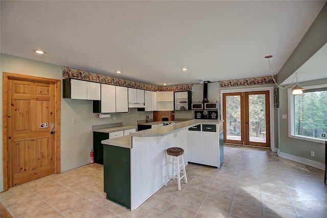 72878 Lemlama Trl, Arlee, MT 59821 - kitchen with light countertops, a kitchen island, white cabinetry, under cabinet range hood, and recessed lighting