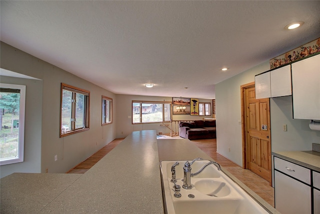 72878 Lemlama Trl, Arlee, MT 59821 - kitchen with a textured ceiling, recessed lighting, white cabinetry, a sink, and open floor plan