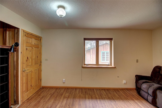 72878 Lemlama Trl, Arlee, MT 59821 - living area with light wood-style flooring, baseboards, and a textured ceiling