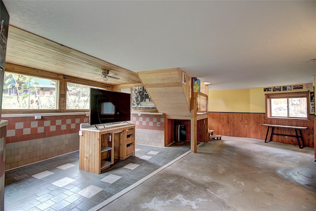 72878 Lemlama Trl, Arlee, MT 59821 - interior space with wainscoting, ceiling fan, wood walls, and concrete flooring