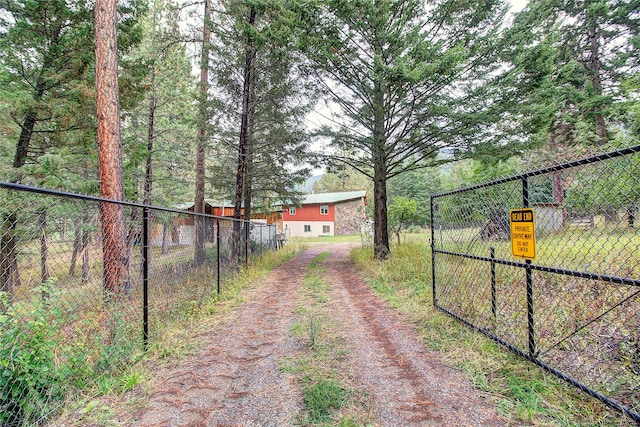 view of yard with a gate, driveway, and fence