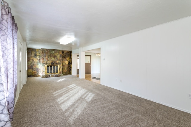 unfurnished living room with carpet floors and a stone fireplace