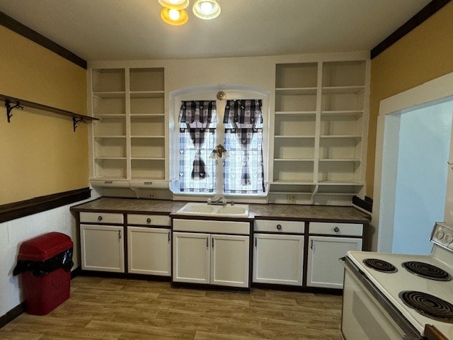 kitchen with white range with electric cooktop, sink, hardwood / wood-style floors, and white cabinetry