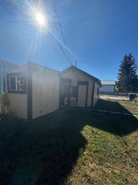 view of side of property featuring a yard and a storage unit