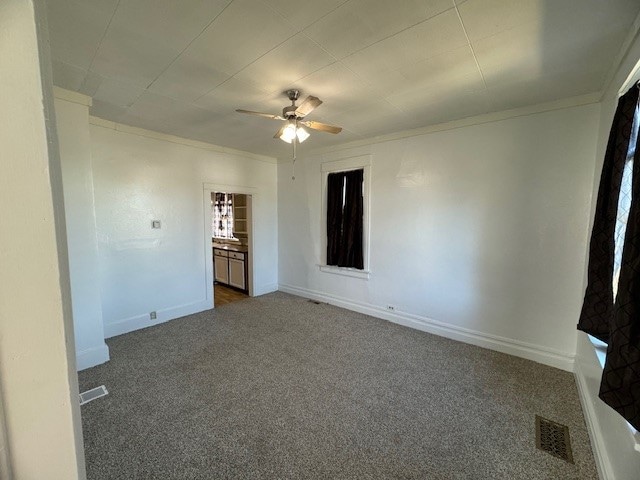 carpeted empty room with ornamental molding and ceiling fan