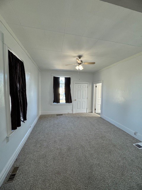 carpeted empty room featuring ceiling fan and crown molding