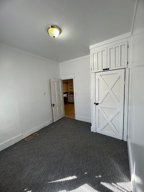 carpeted spare room with crown molding