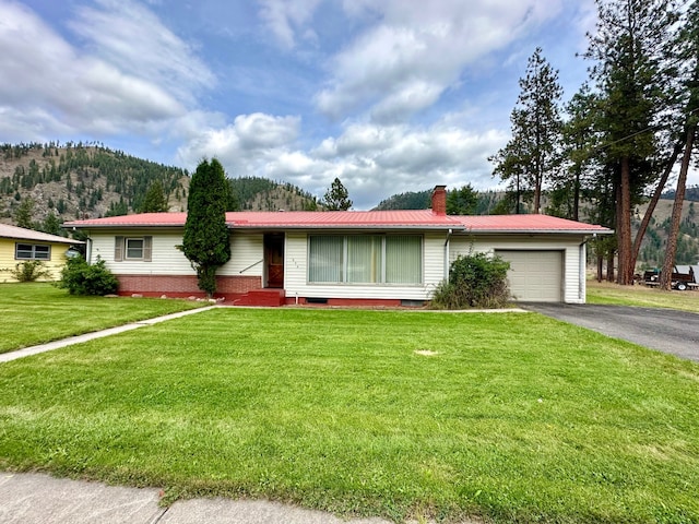 ranch-style house with a mountain view, a front lawn, and a garage