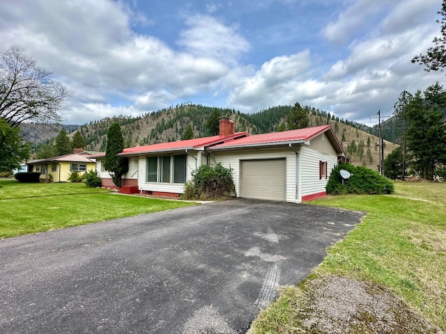 644 4th Ave E, Superior, MT 59872 - ranch-style home with an attached garage, a chimney, driveway, a mountain view, and metal roof