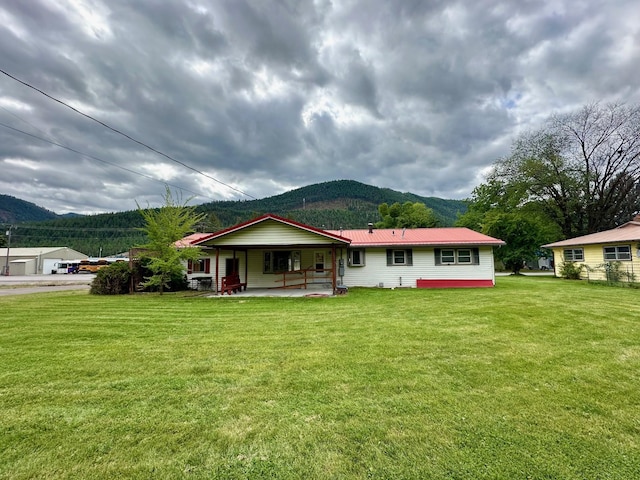 644 4th Ave E, Superior, MT 59872 - view of front of home featuring a mountain view, a front yard, metal roof, and covered porch