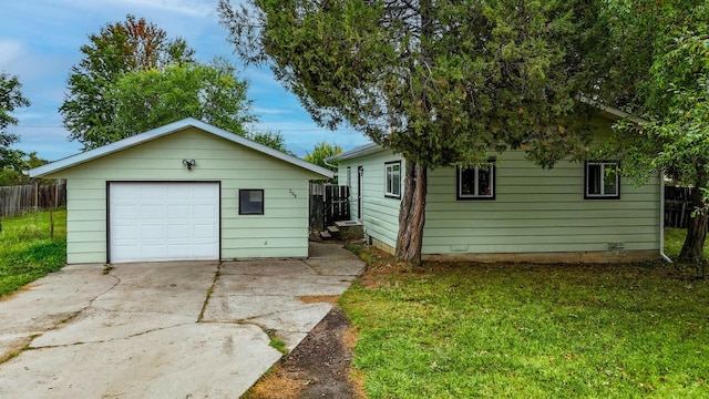 view of front facade with a front yard, an outbuilding, and a garage