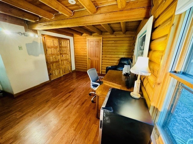 office with beam ceiling, hardwood / wood-style flooring, and log walls