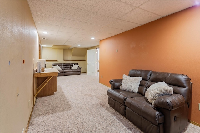 living room featuring a drop ceiling and carpet floors