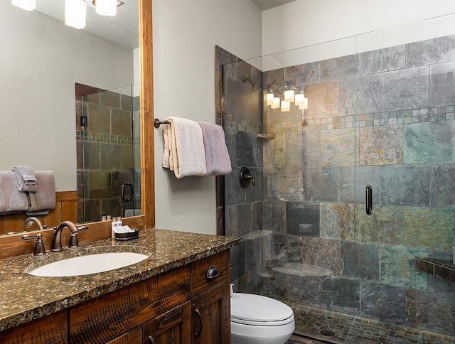 bathroom with vanity, a shower with shower door, and toilet