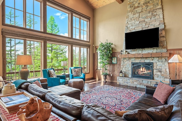 living room with a wealth of natural light, a fireplace, and high vaulted ceiling