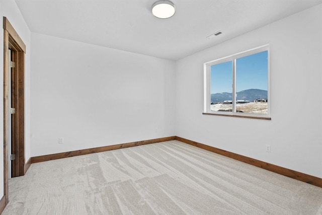 spare room with light carpet and a mountain view