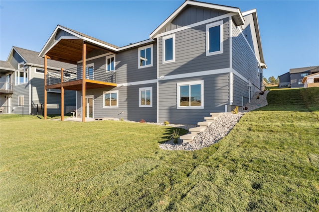 rear view of property with a yard and a balcony