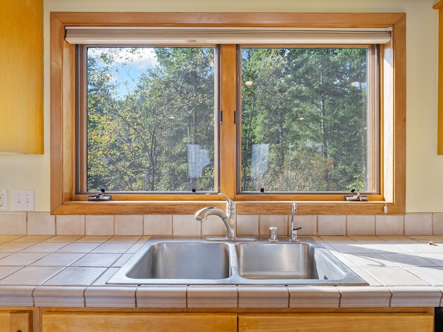 kitchen featuring tile countertops, a healthy amount of sunlight, and sink