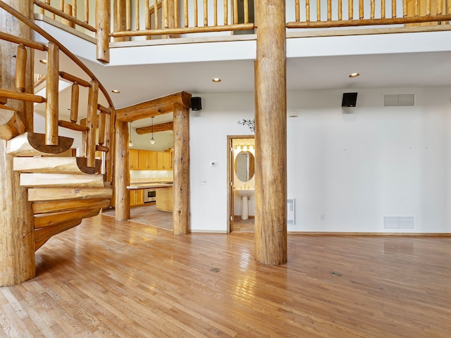 living room featuring sink, a towering ceiling, and hardwood / wood-style floors