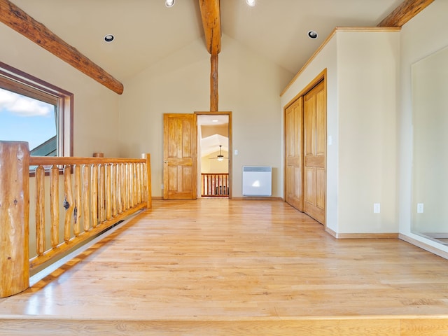 spare room featuring light wood-type flooring, heating unit, beam ceiling, high vaulted ceiling, and ceiling fan