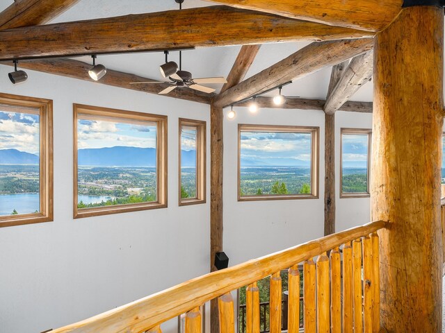 hall featuring a mountain view, beamed ceiling, plenty of natural light, and rail lighting