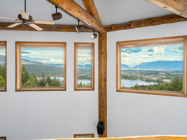 interior space with beam ceiling, ceiling fan, and a water and mountain view