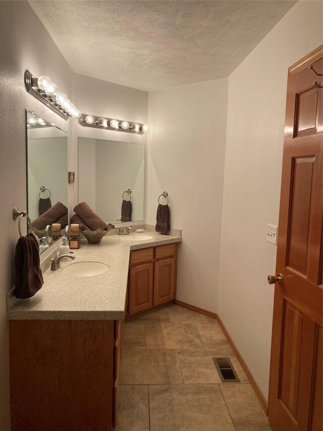 bathroom with vanity, tile patterned flooring, and a textured ceiling