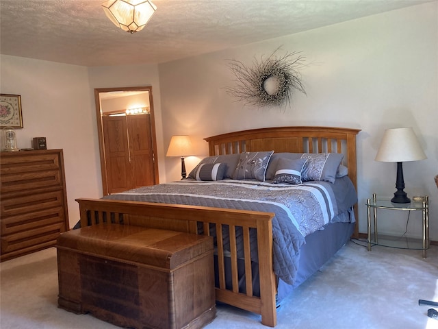 bedroom with light carpet and a textured ceiling