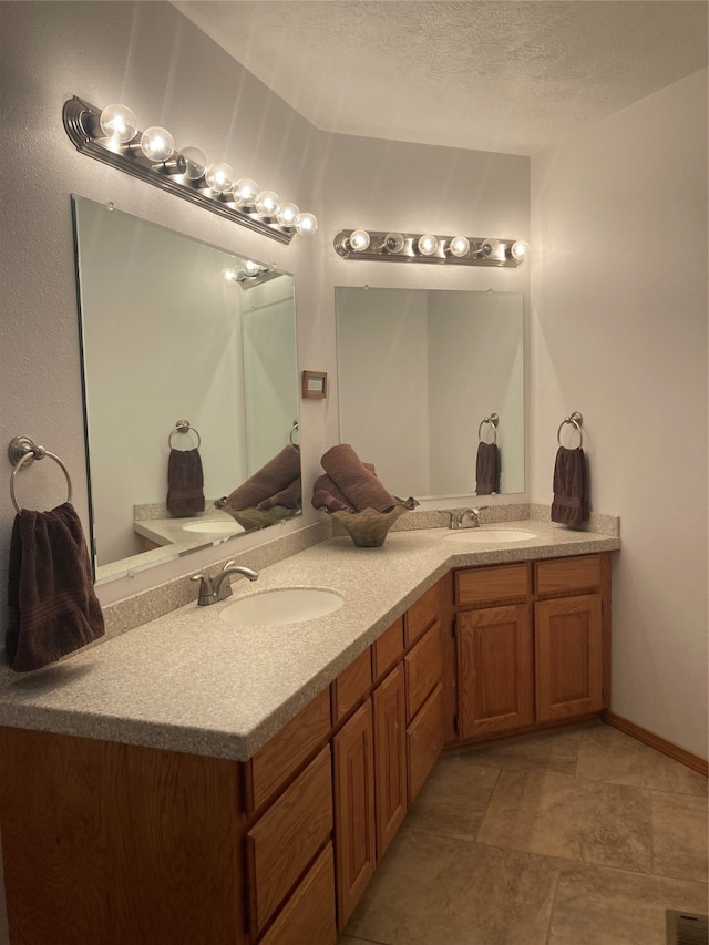 bathroom with a textured ceiling and vanity